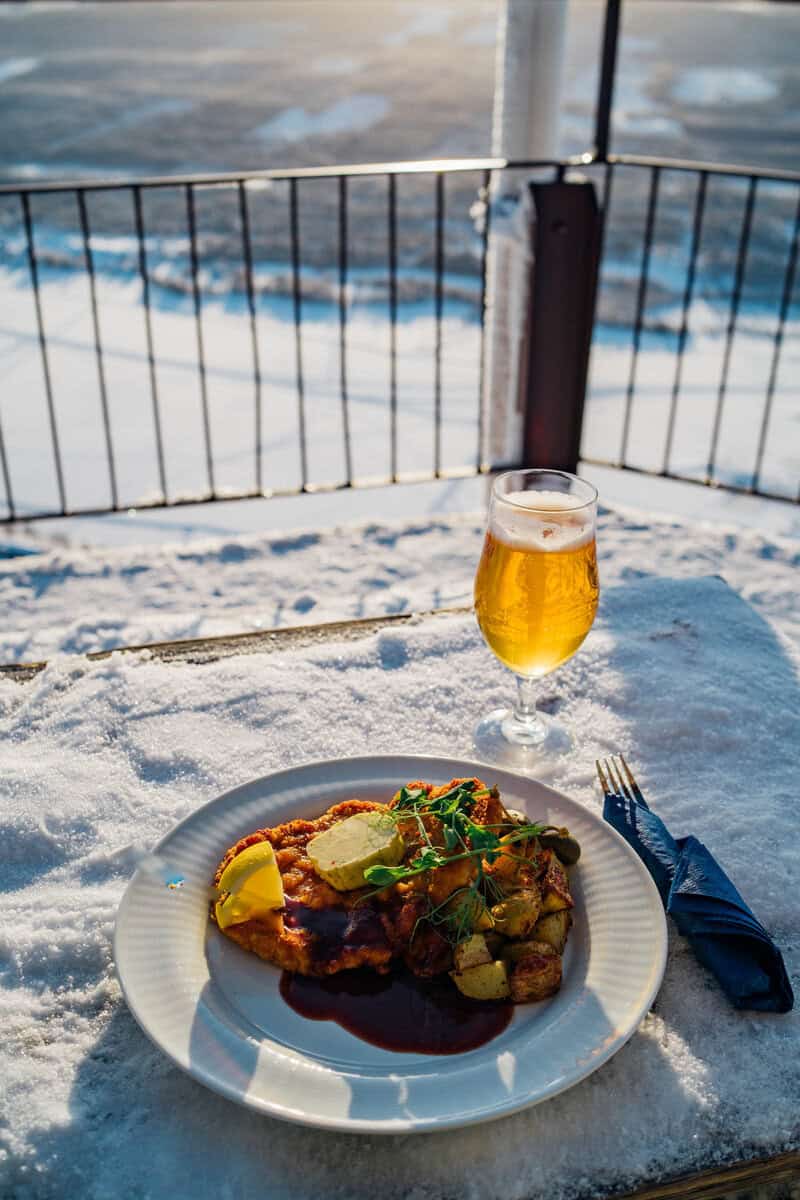 DSC07986 Gott och hälsosamt skidinspirerat måltid på en snöklädd uteplats i Funäsdalen med fjällen i bakgrunden, perfekt för en fjällsemester i Sverige.