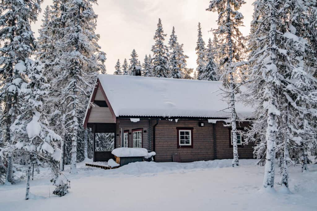 Funktionell trävilla i snötäckt skog, perfekt för fjällsemester i Funäsdalen med skidåkning och vild natur. Idealisk för fjällresor och familjevecka i fjällen.