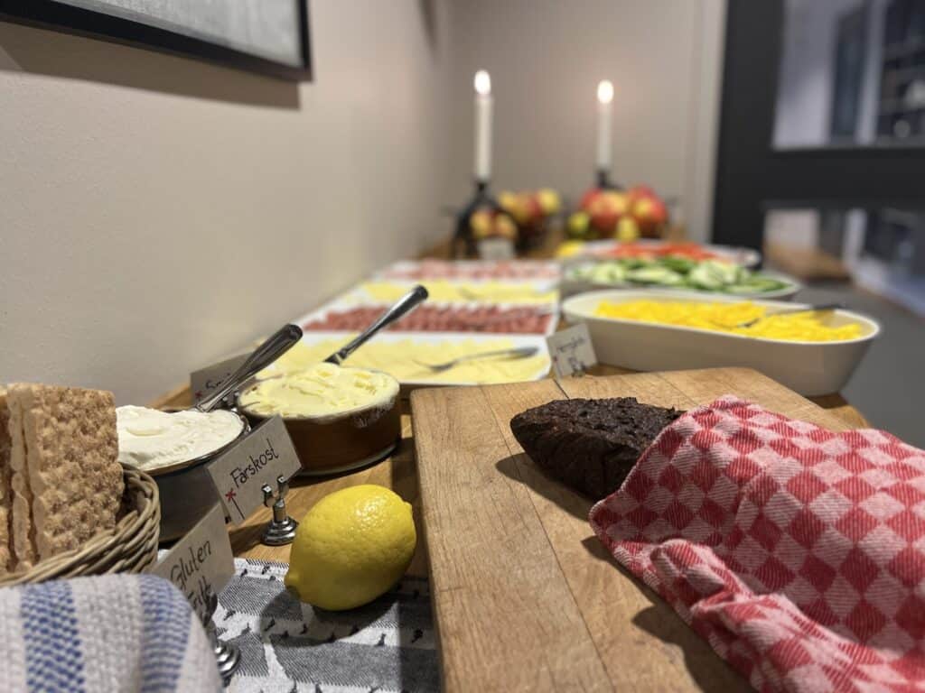Lågupplöst bild av en frukostbuffé med diverse pålägg, bröd, citronskivor och dessertbilder, perfekt för att visa den mysiga och goda frukostupplevelsen i Funäsdalen.